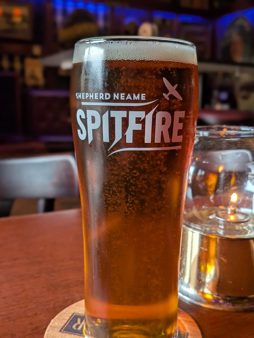 a photo of a pint of if beer. the text on the glass says SPITFIRE. 